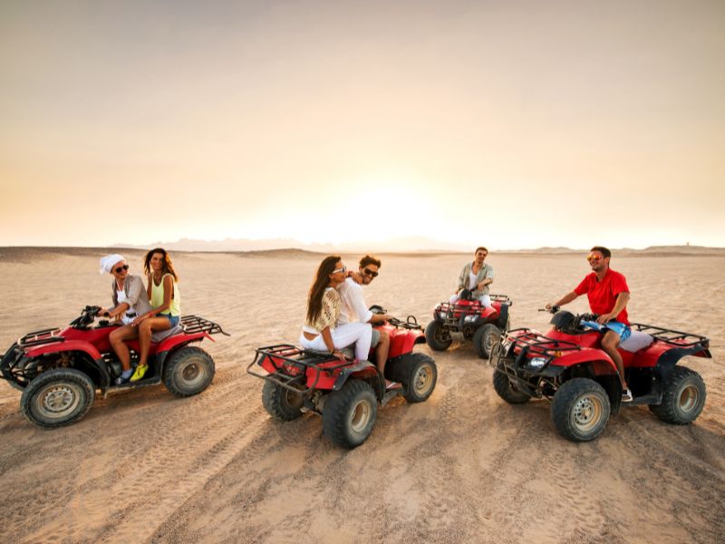 A quad biker racing across the golden dunes of Namibia.